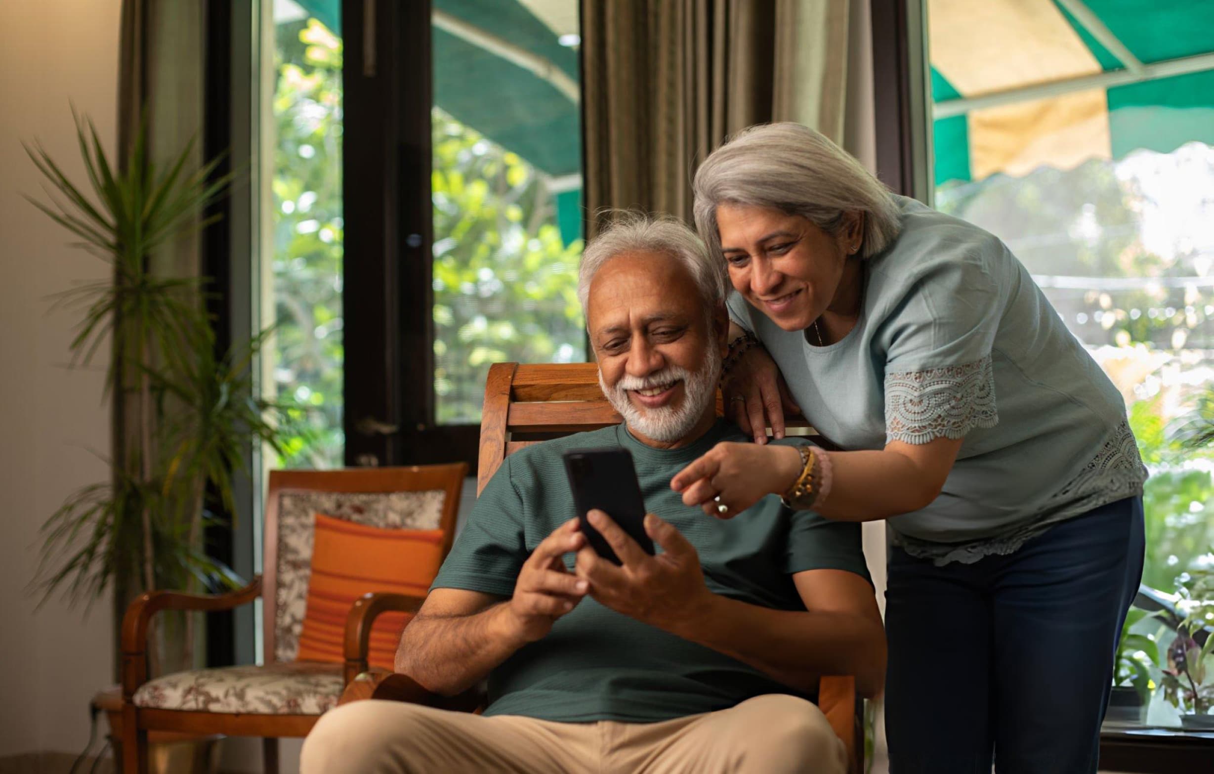 An older couple planning their finances on a phone at home