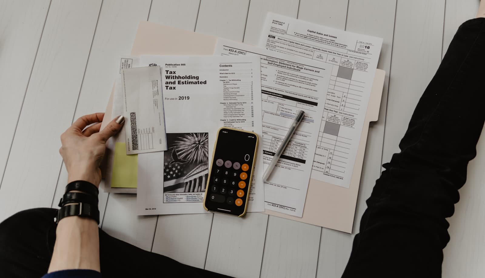 A newsroom desk with financial documents and a laptop